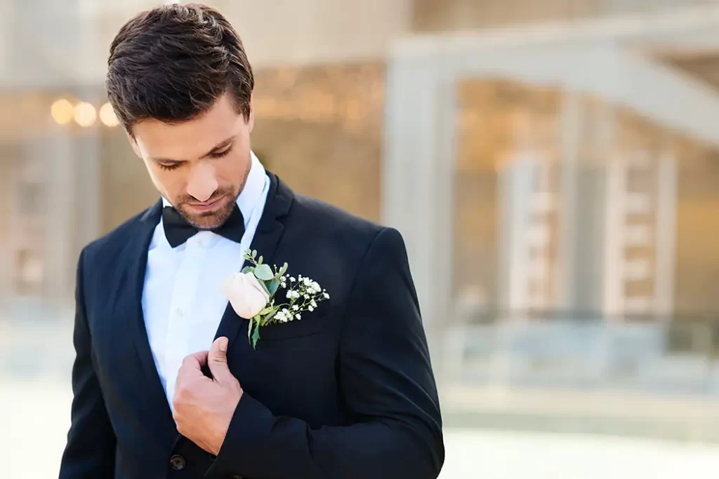 sposo guarda fiori taschino abito